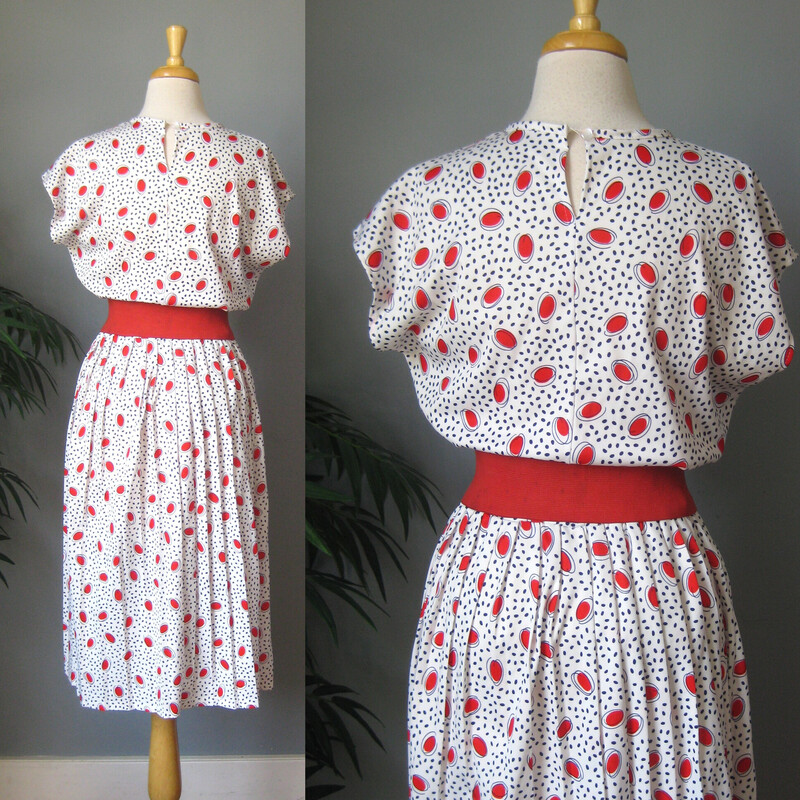 Cute little print dress from the 60s or 70s. It's white with red shapes and black lines.  The waist is elastic.
The skirt is pleated and full
I will send it with the red belt it's shown with even though
    a. it didn't come with it and
    b. the belt, while nice and snappy, is a bit stained.
Ulined.
It has a button and loop at the back of the neck, the elastic on the loop is stretched out.
No tags.
Flat measurements, please double where appropriate:

Armpit to Armpit: 20
Waist: 16 stretches easilyl to 19
Hips: free
Length: 44
Great vintage condition!

Thanks for looking.
#54095