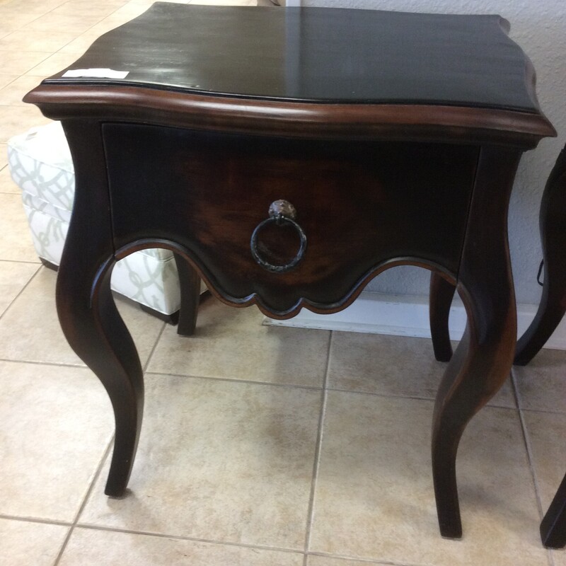 This pair of night stands have a distressed, black painted finish with natural wood showing through. They have cabriol legs and rustic metal hardware.