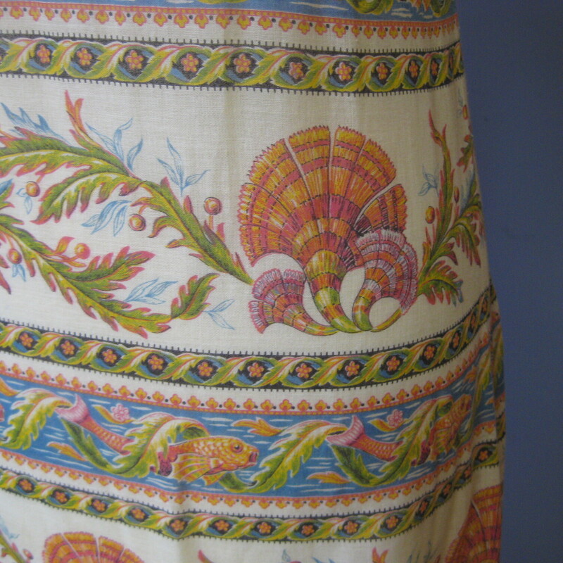 Vtg Sheer Fishie Fish, Cream, Size: XS<br />
Gorgeous, feminine maxi in a baroque orange and white botanical sea life print.<br />
Perfect for an island vacation.<br />
This dress has a label but it is so faded that none of the words can be read so I don't much about it other that what I can see and feel.<br />
It is made of the most lightweight cotton fabric, basically completely sheer.  You will need to wear a bandeau, slip, bike shorts.  maybe a simple one or two piece bathing suit with  it.<br />
It has a metal zipper at center back.<br />
Puffy sleeves and flounce at the bottom.<br />
It is TINY.  My mannequin usually accomodates modern size 4 garments comfortably and you can that this dress fits the mannequin comfortably at the waist and hips, but the upper chest/back of the dress is too slim to zip all the way up.  This dress is probably best for an extremely slim framed woman or a young junior size girl<br />
<br />
The print is so gorgeous, soft orange and green tones, beatifully rendered fish and seashells arranged in horizontal bands.<br />
<br />
It is in excellent condition.<br />
<br />
Here are the flat measurements<br />
shoulder to shoulder: 12.5 this is very narrow, most people require a 17 width at the shoulders.<br />
armpit to armpit: 15.5, again extremely narrow.  18 here is the norm for a modern size small<br />
waist: 15<br />
hip: 19<br />
length: 52<br />
Thanks for looking!<br />
#63783