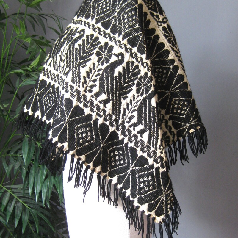 Vtg Cotton Poncho Embrd, Blk/crm, Size: None<br />
This is a gorgeous piece of textile.<br />
Formed into a simple short poncho.<br />
black and white<br />
it's got a cotton base and is embroidered with black wool.<br />
the design is mythical looking birds in bands alternating with a geometric pattern.<br />
<br />
Excellent vintage condition with some rust small diffuse rust spots throughout.<br />
width of neck opening: 15,<br />
length from neck opening to hem at the center: 14.5 not including the fringe, which is 2.5.<br />
<br />
Very wearable because it's short.  Looks amazing on and you can move and work and mingle without your arms behind restricted.<br />
<br />
Thanks for looking!<br />
#65046