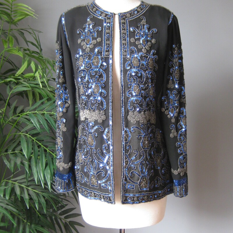 Jack Bryan Seq Evening, Blk/blu, Size: XL
Gorgeous and high quality sequined jacket from the 1990s by
Jack Bryan.

Sleek fit and beautifully constructed. Many of these sequined jackets have a somewhat boxy fit. This one is more modern, narrow at the shoulders and gently shaped at the waist, also a bit longer than the boxier ones.
The jacket is quite substantial (it weighs 2 pounds)
fully lined with shoulder pads.

Lavishly sequined in Blue black and neutral bronze.
No fabric id tags

assembled in Mexico

interior flat measurements:
Shoulder to shoulder: 14.5
armpit to armpit: 18
waist area: 16
Width at hem: 20.25
length: 25.5
underarmt sleeve seam length: 17

Excellent condition, I found no flaws
thanks for looking!
#3800