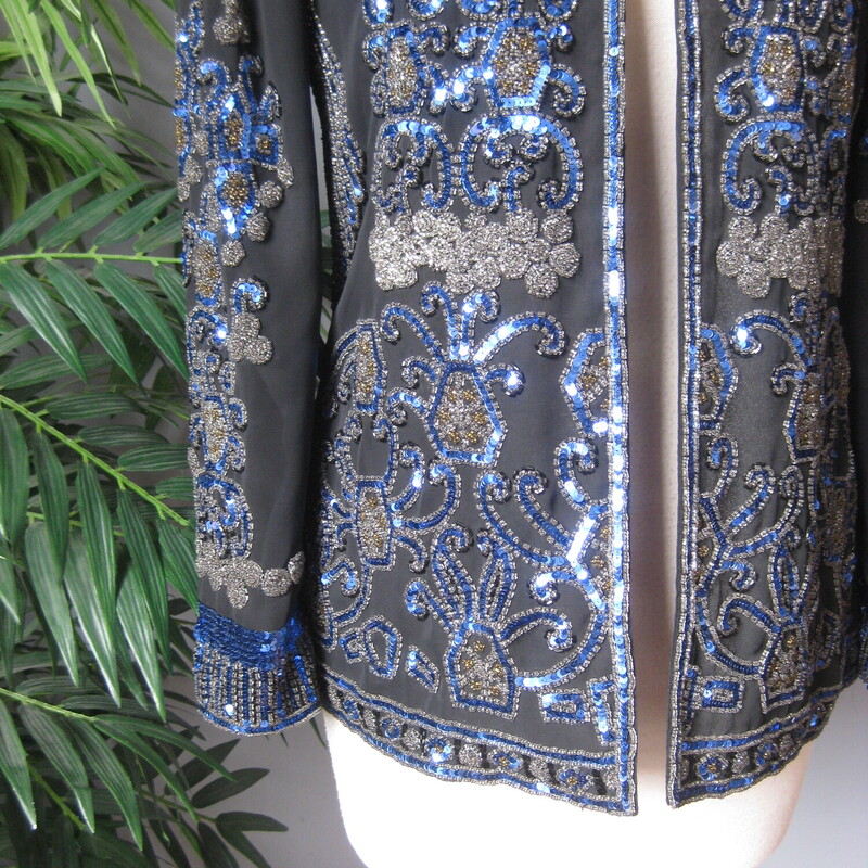 Jack Bryan Seq Evening, Blk/blu, Size: XL<br />
Gorgeous and high quality sequined jacket from the 1990s by<br />
Jack Bryan.<br />
<br />
Sleek fit and beautifully constructed. Many of these sequined jackets have a somewhat boxy fit. This one is more modern, narrow at the shoulders and gently shaped at the waist, also a bit longer than the boxier ones.<br />
The jacket is quite substantial (it weighs 2 pounds)<br />
fully lined with shoulder pads.<br />
<br />
Lavishly sequined in Blue black and neutral bronze.<br />
No fabric id tags<br />
<br />
assembled in Mexico<br />
<br />
interior flat measurements:<br />
Shoulder to shoulder: 14.5<br />
armpit to armpit: 18<br />
waist area: 16<br />
Width at hem: 20.25<br />
length: 25.5<br />
underarmt sleeve seam length: 17<br />
<br />
Excellent condition, I found no flaws<br />
thanks for looking!<br />
#3800