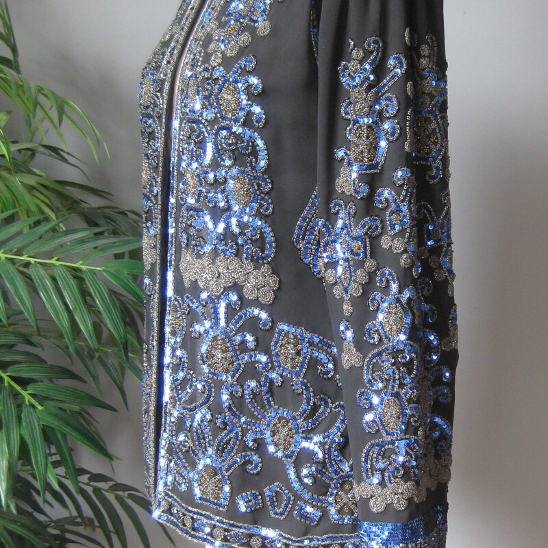 Jack Bryan Seq Evening, Blk/blu, Size: XL
Gorgeous and high quality sequined jacket from the 1990s by
Jack Bryan.

Sleek fit and beautifully constructed. Many of these sequined jackets have a somewhat boxy fit. This one is more modern, narrow at the shoulders and gently shaped at the waist, also a bit longer than the boxier ones.
The jacket is quite substantial (it weighs 2 pounds)
fully lined with shoulder pads.

Lavishly sequined in Blue black and neutral bronze.
No fabric id tags

assembled in Mexico

interior flat measurements:
Shoulder to shoulder: 14.5
armpit to armpit: 18
waist area: 16
Width at hem: 20.25
length: 25.5
underarmt sleeve seam length: 17

Excellent condition, I found no flaws
thanks for looking!
#3800