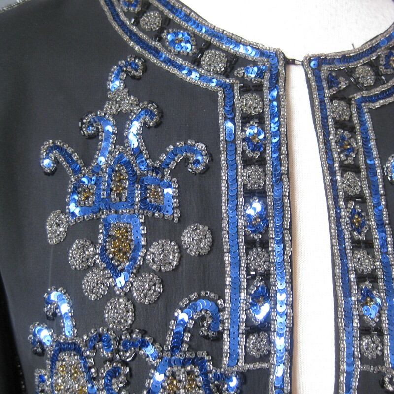 Jack Bryan Seq Evening, Blk/blu, Size: XL<br />
Gorgeous and high quality sequined jacket from the 1990s by<br />
Jack Bryan.<br />
<br />
Sleek fit and beautifully constructed. Many of these sequined jackets have a somewhat boxy fit. This one is more modern, narrow at the shoulders and gently shaped at the waist, also a bit longer than the boxier ones.<br />
The jacket is quite substantial (it weighs 2 pounds)<br />
fully lined with shoulder pads.<br />
<br />
Lavishly sequined in Blue black and neutral bronze.<br />
No fabric id tags<br />
<br />
assembled in Mexico<br />
<br />
interior flat measurements:<br />
Shoulder to shoulder: 14.5<br />
armpit to armpit: 18<br />
waist area: 16<br />
Width at hem: 20.25<br />
length: 25.5<br />
underarmt sleeve seam length: 17<br />
<br />
Excellent condition, I found no flaws<br />
thanks for looking!<br />
#3800