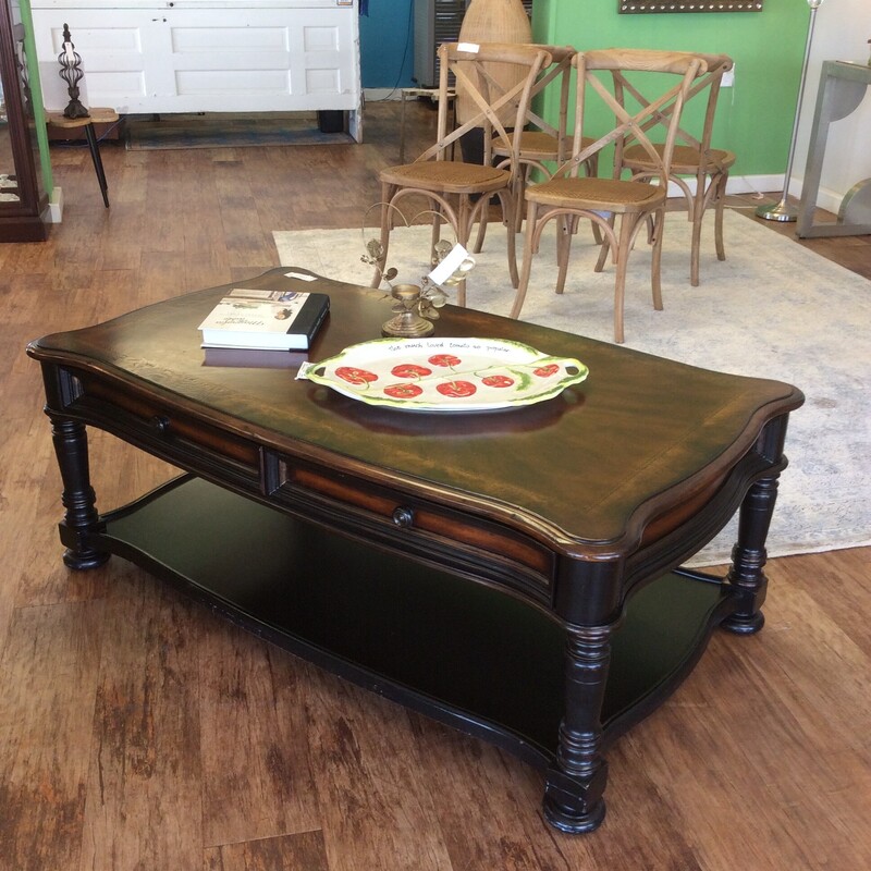 This is a beautiful coffee table by Hooker Furniture. From the Seven Seas Collection, it's more traditional in style and certainly possesses an Old World Charm. The bottom has been painted black and there are 2 roomy drawers.
