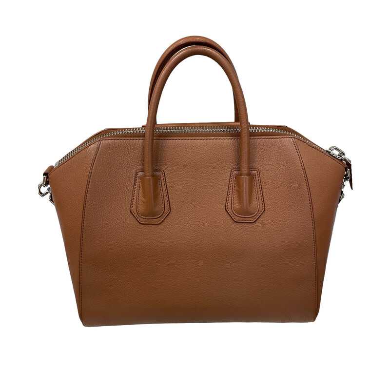 Givenchy Antigona Medium Brown Handbag<br />
<br />
Size: Medium<br />
<br />
100% calfskin leather. Lining : 100% cotton. Metal pieces: 100% zamac.<br />
<br />
Dimensions:<br />
13.19 in x 11.02 in x 6.5 in<br />
Strap length: 30 in. Handle: 3.1 in.<br />
<br />
Medium handbag or shoulder bag in Box calfskin leather.<br />
Antigona line.<br />
Zipper closure with GIVENCHY 4G zipper pull.<br />
Pentagonal patch with silvery debossed GIVENCHY signature.<br />
Leather handles.<br />
Adjustable and removable strap in leather.<br />
Silvery-finish metal details.<br />
One main compartment with two flat pockets and one zippered pocket inside.