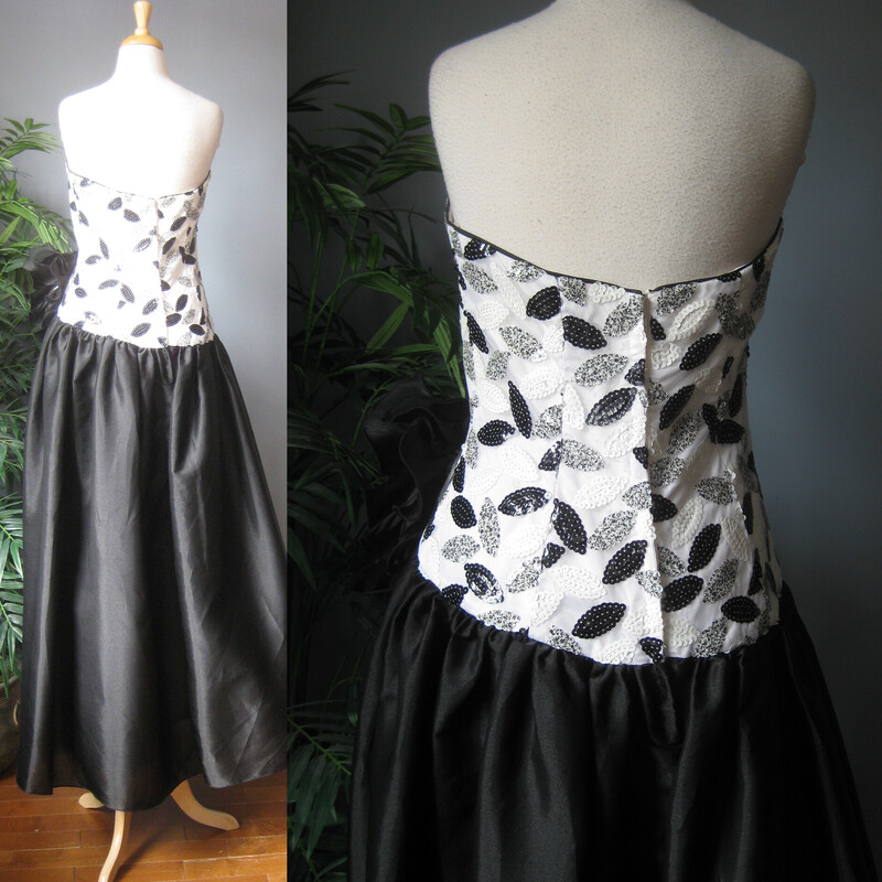 A dramatic gown  by Eugene Alexander from the 80s 90s.
Body conforming sequined strapless bodice in black and white.
Very full satin skirt that begins at the hips for that dropped waist silhouette so popular in that time.
Very high quality and quite heavy.
The dress has a built in crinoline under the skirt


The 3D Flowers and embellishments at the waist are tacked on and can easily be removed if desired. And repurposed!
Made in the USA
Marked size 12 - but probably best for a size M pls use the measurements here as your ultimate guide
Here are the flat measurements please double where appropriate:
armpit to armpit:  16.25  bodice is boned and shaped at the bust, you need it to be tight here to help hold it up.
waist: 15.5
hip: up to 33 super ful here, not supposed to be close to the body
Length from cetner of bodice to hem:  53
Thank you for looking!
#68376