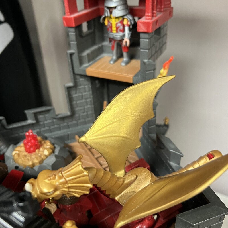 Playmobil Great Asian Castle 5479 & set 6038, Red/Grey/Black, Size: 5-12Y<br />
Mini Figures Complete<br />
<br />
Enemies beware! The Great Asian Castle is protected by a fierce fire-breathing dragon. When not flying around, the yellow dragon can guard the castle from the attachable landing platform. This fortified castle also includes plenty of features to help the soldiers defend it. The functioning portcullis keeps unwanted visitors out, while anyone who manages to sneak into the castle will be caught off by the hidden trapdoor. The trapdoor can also act as a secret getaway for the castle warriors. Keep enemies at bay using the functioning crossbow with flaming arrows. The rocky landscape also conceals a secret cave where kids can hide the sacred dragon fire, which lights up (batteries not included). Set also includes four figures, helmets, shields and additional battle gear, skeleton, torches, flags and other accessories.