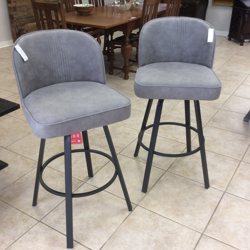 This pair of counter height bar stools is upholstered in a soft grey fabric.