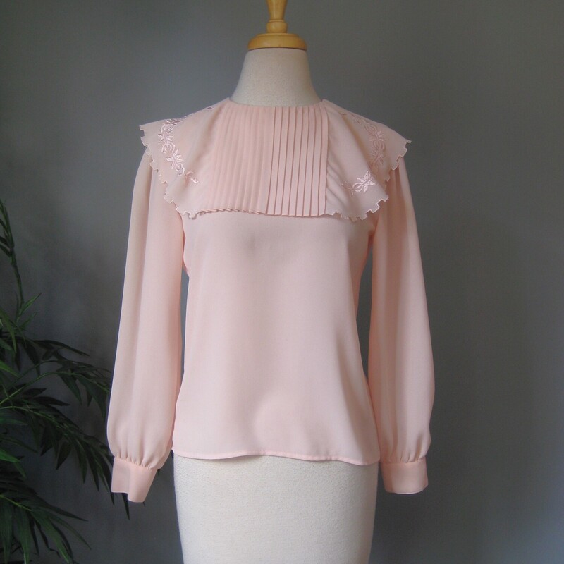 Vtg Josephine Secretary, Pink, Size: 10
Sweet blouse with long sleeves with button cuffs and an embroidered capelet collar
The little cape goes across the front, over the shoulders and meets at the center back where the shirt closes with a button and elastic loop.
The capelet has a 'dentil' shaped edge and tonal satin stitch floral embroidery.
It's by Josephone madein Korea
no fabric id but it's certainly a polyester, no stretch
Flat measurements:
Shoulder to shoulder: 14.5
Armpit to Armpit: 18.75
Waist: 19
length: 21
underarm sleeve seam: 17

excellent condition, two tiny spots, one on the edge of the capelet and one on one of the cuffs as shown.

thank for looking!
#2411