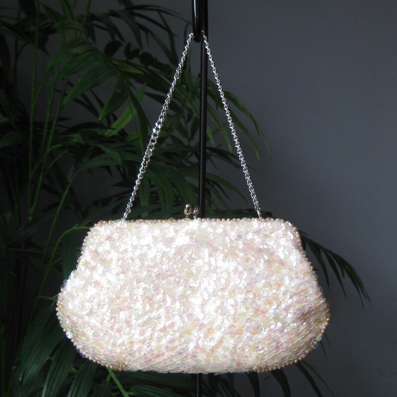 Vtg Japanese Beaded, Ivory, Size: N<br />
Sweet little sequined clutch by from the 1950s with a chain strap and kisslock freame.<br />
Made in Japan<br />
covered with irridescant clear sequins, silver beads and pearls in an art deco style design.<br />
White satin interior<br />
<br />
Measurements:<br />
Width: 8.25<br />
Height: 4.75<br />
when empty<br />
strap drop: 5<br />
<br />
<br />
Thank you for looking.<br />
#65828