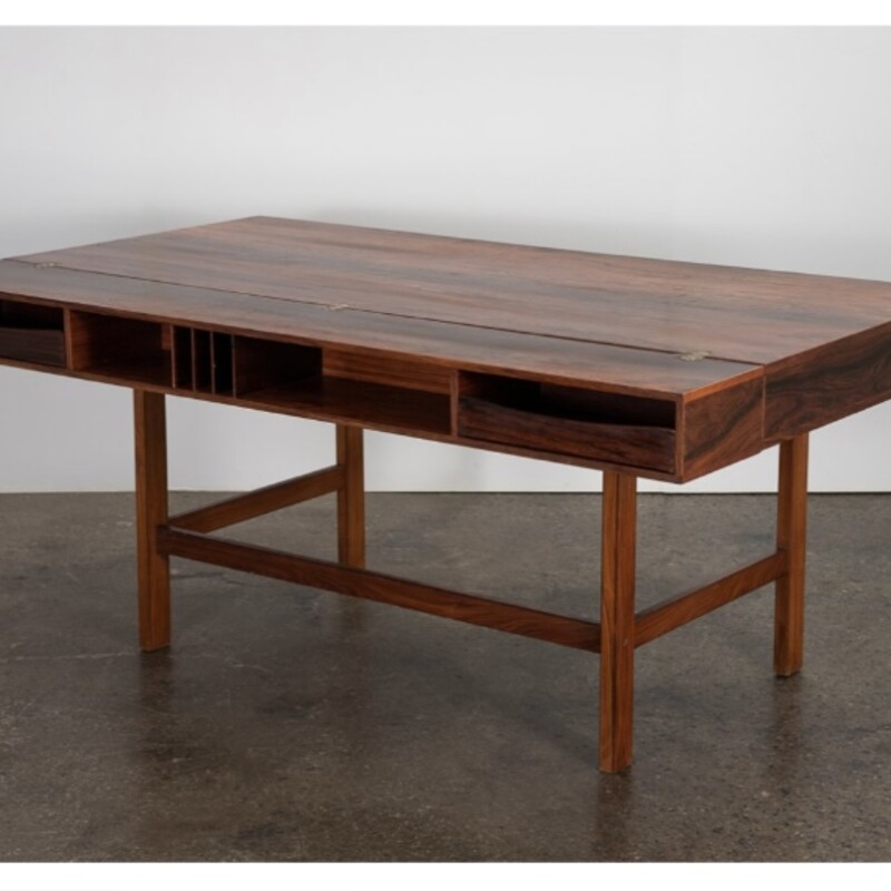 Peter Lovig Flip Top

Size: 64Lx29Dx34H

Stunning rosewood flip-top partner desk by Peter Lovig Nielsen. The desk features beautiful rosewood grain throughout. The top shelf of the desk flips down to extend the work surface allowing it to be used as a partner’s desk.