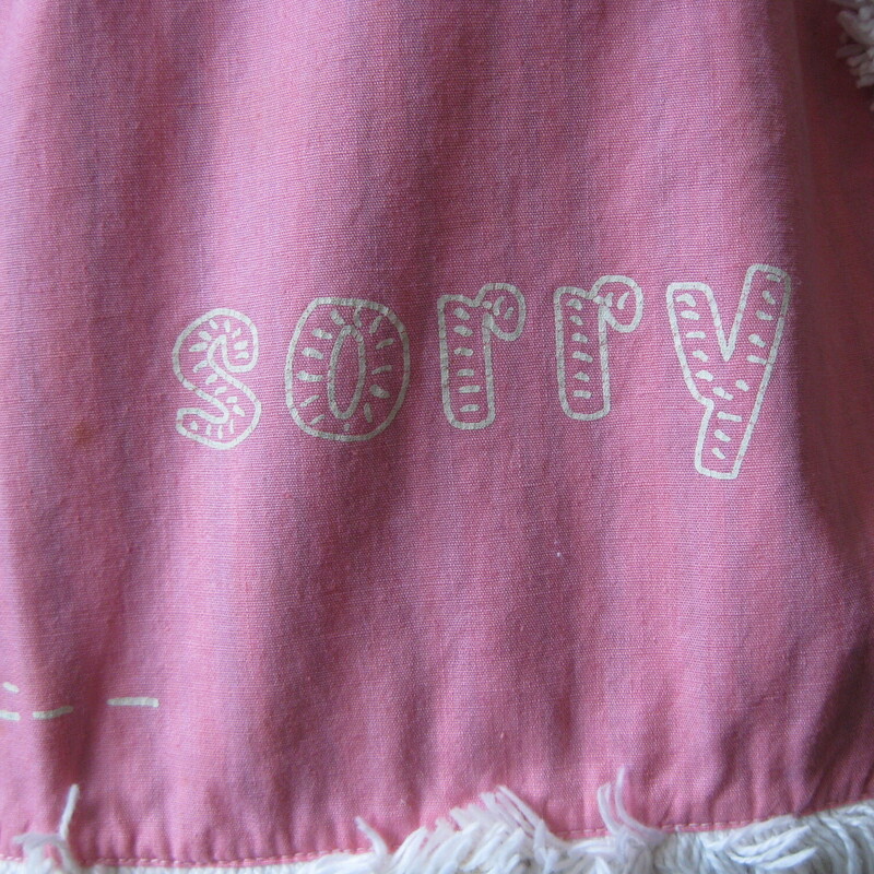 Vtg Graphic Apron, Multi, Size: None<br />
Unusual theme for a pretty apron made in the 70s of cotton.<br />
It features a sweet holly hobby like graphic with the word Sorry on the front.<br />
This graphic part is surrounded by brushy white fringe.<br />
The base of the apron is a vertical multicolor striped cotton.<br />
<br />
The apron measures 72 from end to end, the sashes are long enough to make a nice big crisp bow at the back as shown.   the body of the apron measures 16 at the waist, 29 at the bottom<br />
Thank you for looking.<br />
#66306