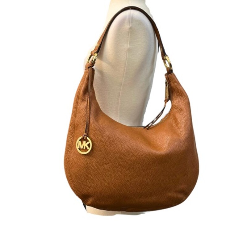 Michael Kors Rhea Zip Shoulder Bag<br />
Suntan Pebbled Leather with Gold-plated hardware that adds a touch of luxury.<br />
Inside, the bag has multiple inner pockets and pockets to keep your essentials organized. The canvas and fabric lining material add durability to the bag.<br />
Width: 14<br />
Height: 10<br />
Depth: 5