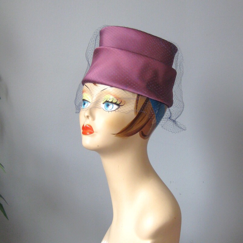 Vtg Satin Toqe, Purple, Size: None<br />
This tailored turban style hat is chic!  It's made of a lustrous satin fabric draped and folded around a firm hat body.  It has a blue netting over over the top and sides.<br />
<br />
It is in excellent vintage with excellent workmanship. It measures approximately 20.75 around the inside band. You might need a pin to attach it to your hair.<br />
<br />
Please note:  my mannequin has a smaller than average head.  This hat is most likely going to sit a bit higher or further back on your head than it does on hers.<br />
<br />
Thank you for looking.<br />
#63063
