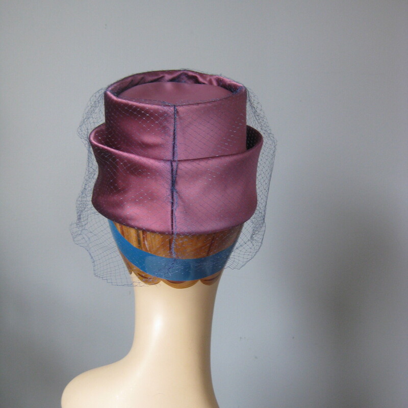 Vtg Satin Toqe, Purple, Size: None<br />
This tailored turban style hat is chic!  It's made of a lustrous satin fabric draped and folded around a firm hat body.  It has a blue netting over over the top and sides.<br />
<br />
It is in excellent vintage with excellent workmanship. It measures approximately 20.75 around the inside band. You might need a pin to attach it to your hair.<br />
<br />
Please note:  my mannequin has a smaller than average head.  This hat is most likely going to sit a bit higher or further back on your head than it does on hers.<br />
<br />
Thank you for looking.<br />
#63063