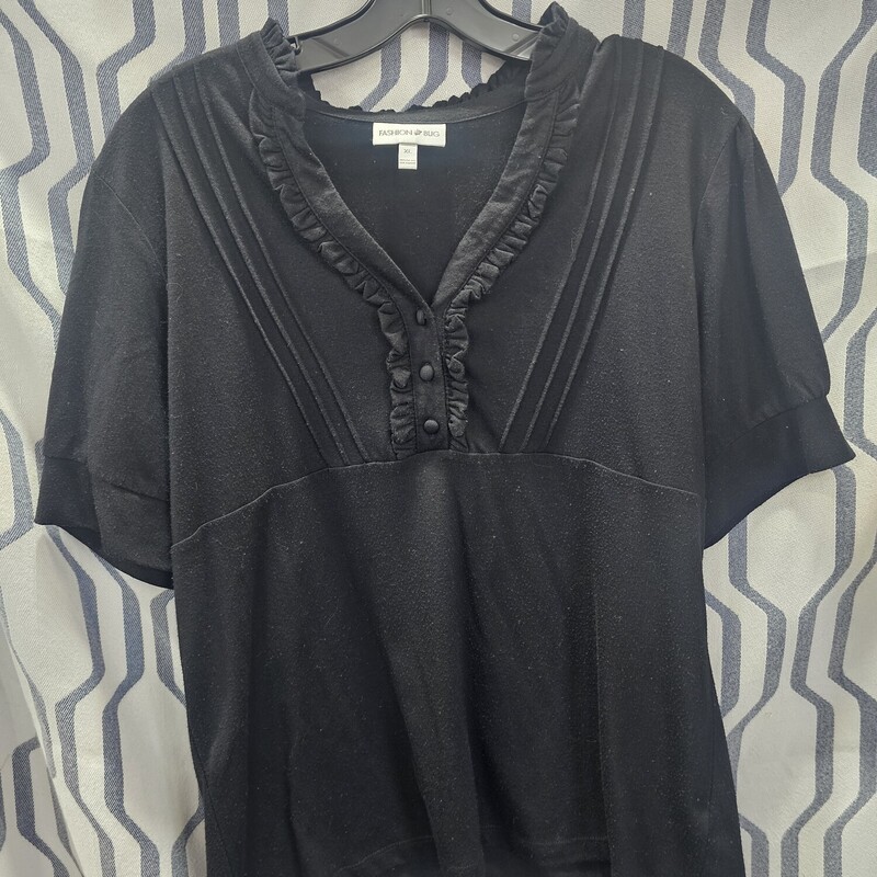 Short sleeve knit top in black with ruffled embellished front chest panel. v neck style and banded cuffs on the arms.