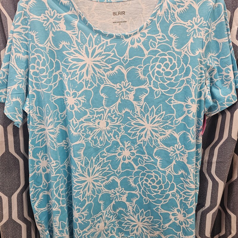 Short sleeve knit top in blue with white floral design. Crew cut neckline.