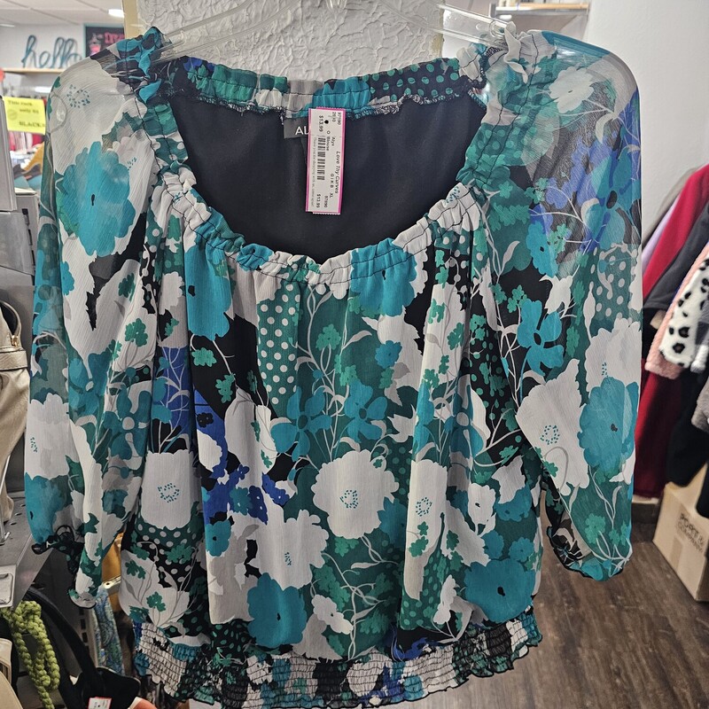 Beautiful bold printed floral design on a half sleeve blouse with a banded elastic waist hem and elastic cuffs. Super cute for work or play.