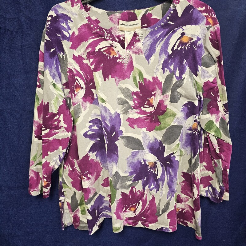 Half sleeve knit top in a fun and bold floral print. Complete with silver embellishment along the neckline.