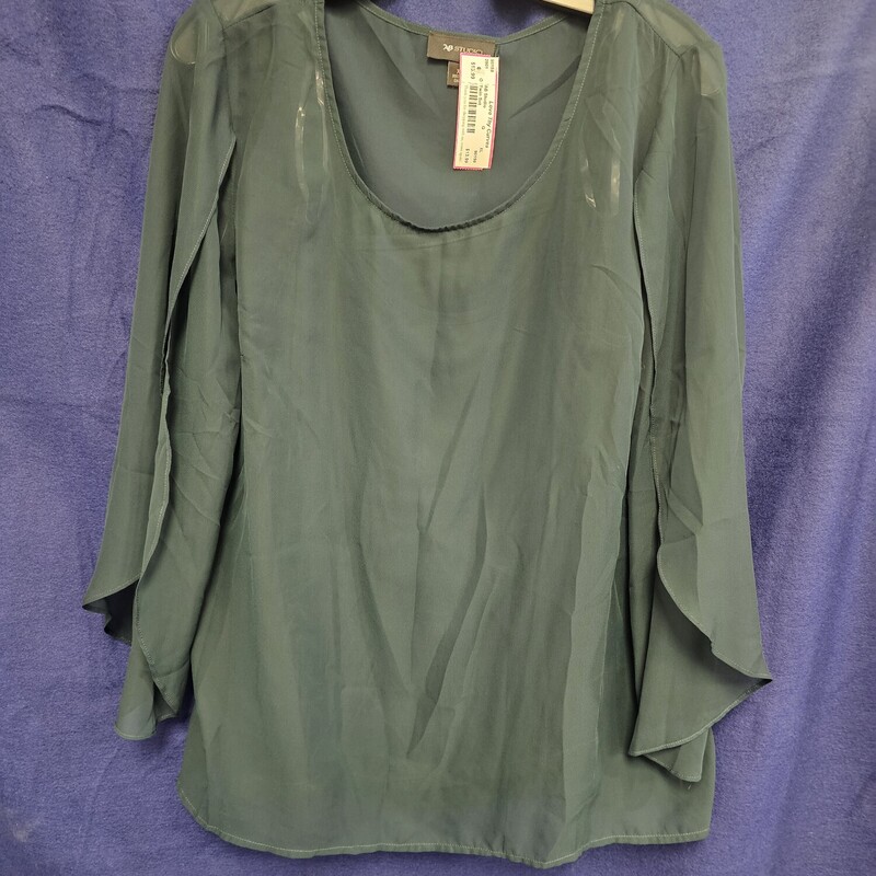 Beautiful green sheer blouse over a spaghetti strap tank in the same color.