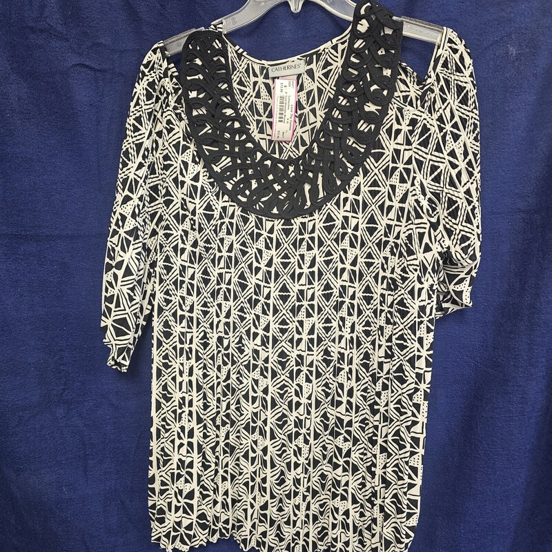 Black and white patterned cold shoulder blouse with short sleeves.
