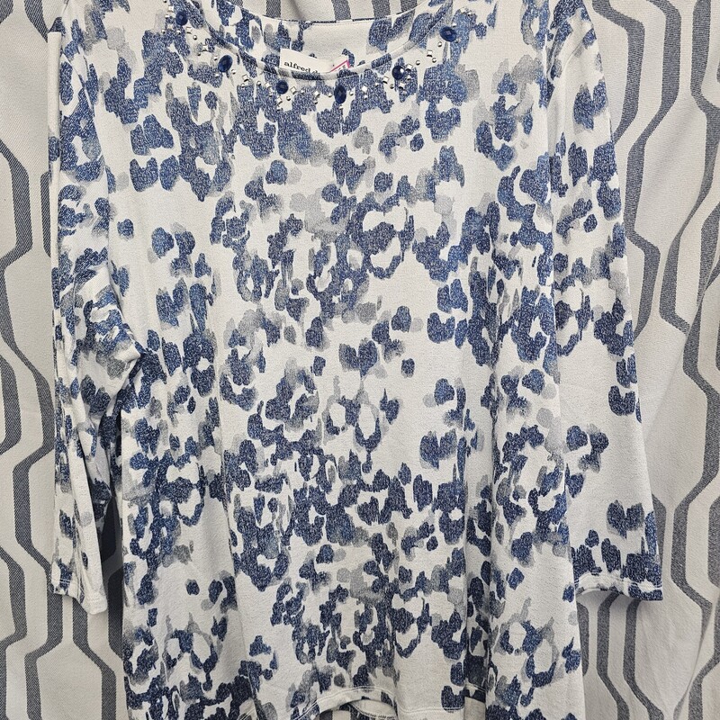 Half sleeve knit top in white with blue and grey print and embellishment on the neckline