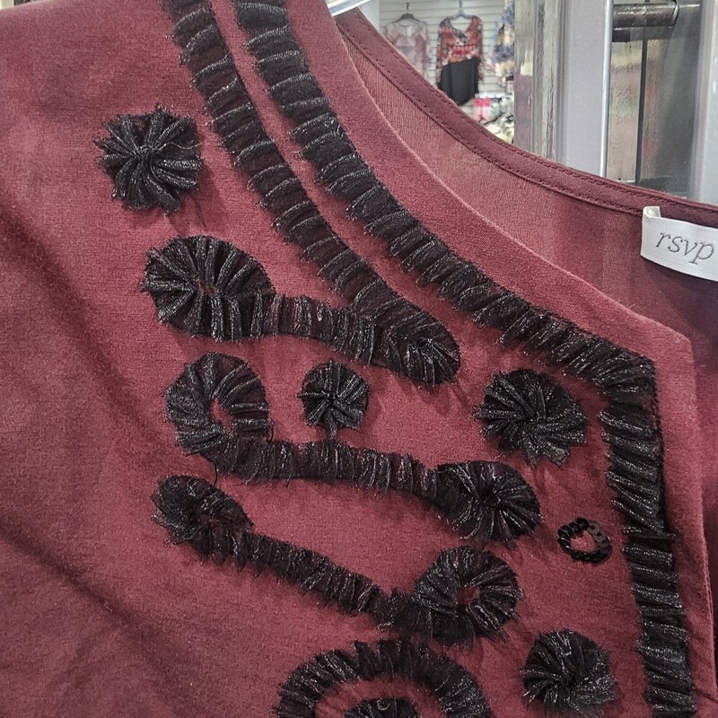 Love this blouse for year round appeal. Burgandy with black macrame style embellishment and ruffled cuffs