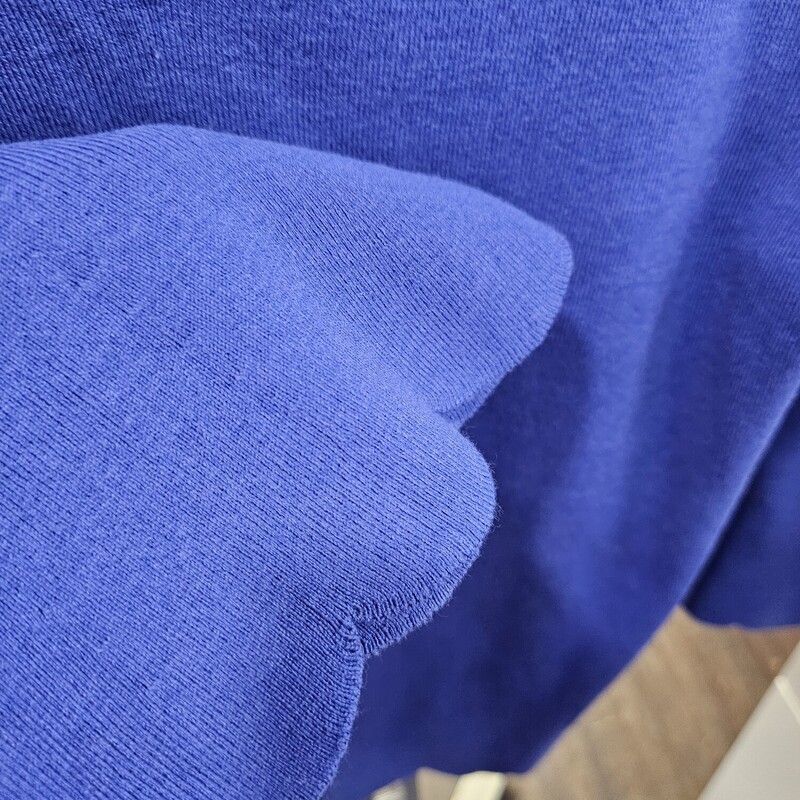 Brand new with tags, blue light weight sweater with cuffs and hemline having a scalloped design.