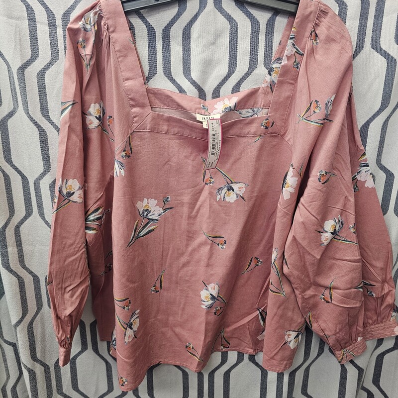 Brand new but without the tags, this blouse is done in a mauve pink with floral design and half sleeves