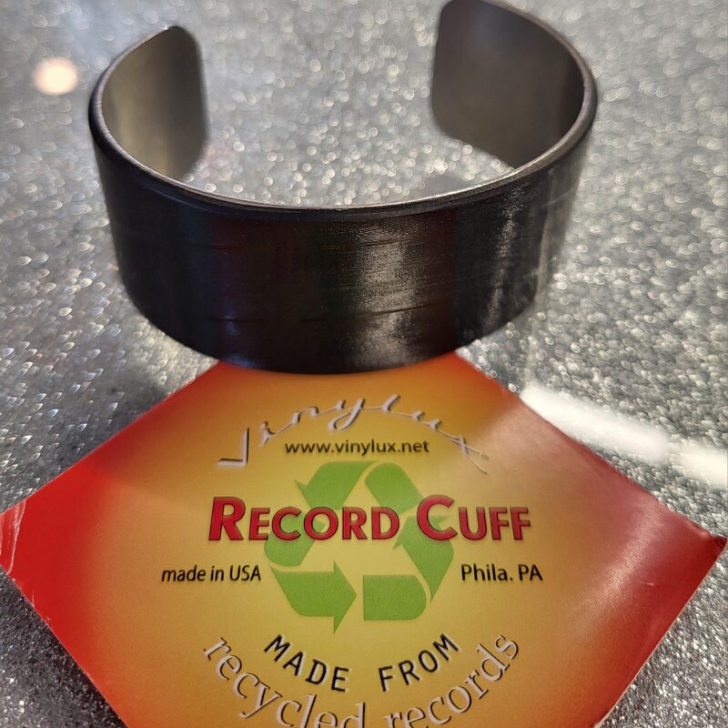 These record cuffs are created from authentic vintage vinyl records, and are the perfect accessory for fashionable vinyl enthusiasts of any gender.

These record cuffs are made of rhodium-plated brass, and are adjustable to fit any size wrist!

This simple, yet captivating piece of jewelry showcases the shine of the record grooves with every movement of your hand!

These cuffs are 1-1/8in wide, by 2-1/2in in diameter, and can be adjusted to any size or shape wrist by running under hot water for 2 minutes, and gently adjusting by hand. Packaged in a clear plastic box. Made by hand in Philadelphia, PA.