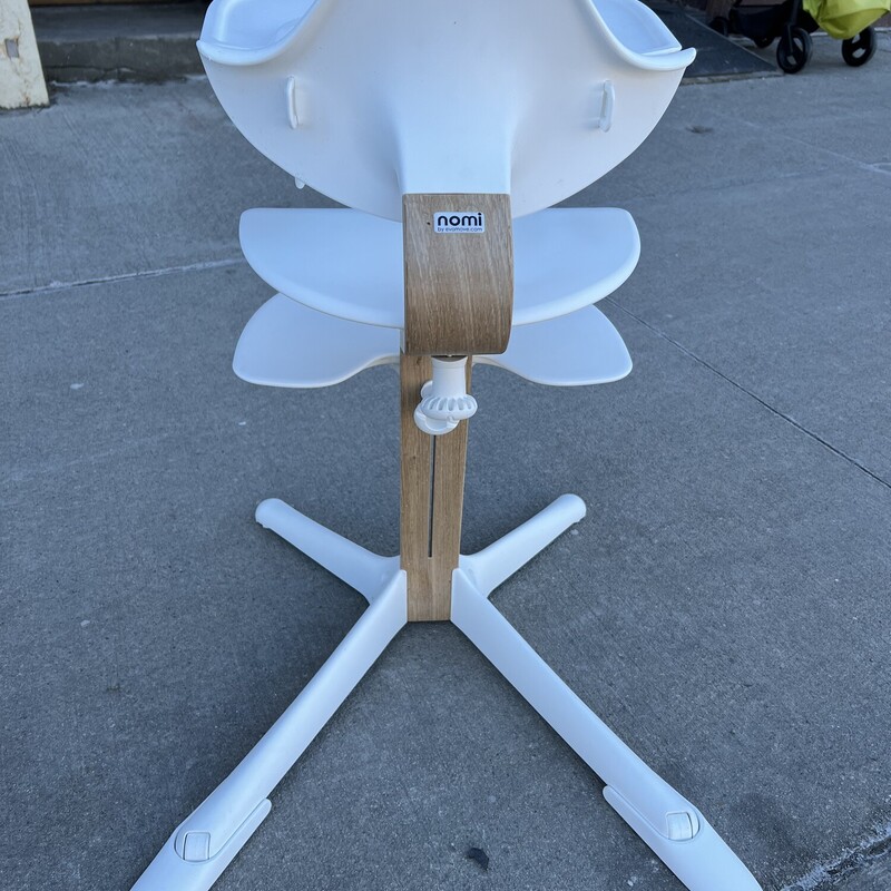 Nomi White Oak with White Seat Highchair, Age:6-24M<br />
<br />
Includes Baby Seat and Tray<br />
<br />
The Nomi High Chair is designed for children approximately 6-24 months. Nomi is the next generation high chair that seamlessly adjusts without tools, and evolves with children’s changing needs from birth with the Nomi Baby all the way through the teenage years as the Nomi Chair! Scandinavian design by world renowned seating expert - Peter Opsvik, who spent his entire career studying what he calls ‘active sitting’. His philosophy is that children need a stable platform for their feet from which to move – so the child will sit actively and varied – but stay seated.<br />
<br />
Nomi easily transforms from a raised bouncer for your newborn—to a high chair—to a chair, so your child is positioned in the most comfortable & ergoNOMIc position from newborn all the way to adulthood, holding up to 330 lbs. Unlike traditional high chairs that cannot be used until your baby can sit up on their own, Nomi allows you to bring your newborn up to the table with the addition of the Nomi Baby raised bouncer attachment.<br />
<br />
The Nomi High Chair is EASY TO CLEAN which is one of the top requirements for parents when looking for a high chair! Its sleek design doesn’t trap food and Nomi is lightweight which makes cleaning a breeze—you can even hang it on the table edge to clean underneath. When sitting in either a booster seat or an adult chair with dangling feet, children get fidgety and uncomfortable, making it hard for them to focus on their meal.<br />
<br />
The Nomi Chair brings your child up to the table and the floor up to their feet, so they are always comfortable, like you are in a regular adult-sized chair. Not just for meals—perfect for all activities, homework, crafts, coloring, games, or just spending time with family. Manufactured in Europe with environmentally responsible components. Seamless adjustment of the seat and footrest with no tools required.<br />
<br />
Features:<br />
The Nomi High Chair is designed for children approximately 6-24 months.<br />
Nomi believes that family meal time is special; conversation, socialization, and special moments all occur around the dining table. With the Nomi, you make sure that everyone is included, even the youngest family members.<br />
Easily transforms from infant High Chair to Chair - allows you to position your child in the most comfortable & ergonomic position from newborn all the way to adulthood, the strong and sturdy wooden stem holds up to 330 lbs.<br />
Tested best as the #1 HIGH CHAIR (2018) by Stiftung Warentest in Germany. JPMA certified and meets the latest 2018 ASTM safety standards.<br />
Scandinavian design by world renowned seating expert - Peter Opsvik. Manufactured in Europe with environmentally responsible components.<br />
EASY TO CLEAN - Its sleek design doesn't trap food and lightweight design allows you to hang it on the table edge to clean underneath.