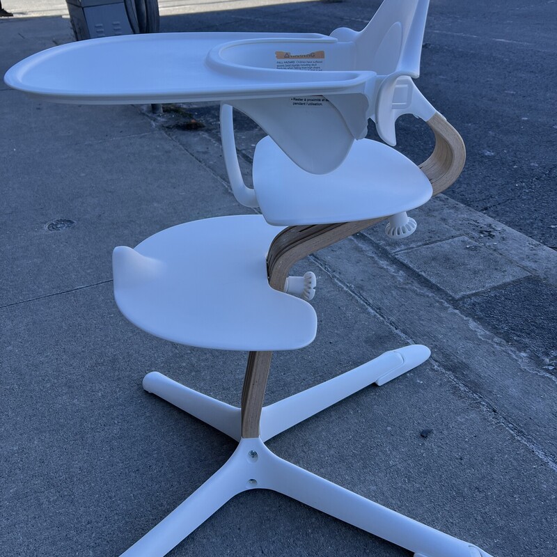 Nomi White Oak with White Seat Highchair, Age:6-24M<br />
<br />
Includes Baby Seat and Tray<br />
<br />
The Nomi High Chair is designed for children approximately 6-24 months. Nomi is the next generation high chair that seamlessly adjusts without tools, and evolves with children’s changing needs from birth with the Nomi Baby all the way through the teenage years as the Nomi Chair! Scandinavian design by world renowned seating expert - Peter Opsvik, who spent his entire career studying what he calls ‘active sitting’. His philosophy is that children need a stable platform for their feet from which to move – so the child will sit actively and varied – but stay seated.<br />
<br />
Nomi easily transforms from a raised bouncer for your newborn—to a high chair—to a chair, so your child is positioned in the most comfortable & ergoNOMIc position from newborn all the way to adulthood, holding up to 330 lbs. Unlike traditional high chairs that cannot be used until your baby can sit up on their own, Nomi allows you to bring your newborn up to the table with the addition of the Nomi Baby raised bouncer attachment.<br />
<br />
The Nomi High Chair is EASY TO CLEAN which is one of the top requirements for parents when looking for a high chair! Its sleek design doesn’t trap food and Nomi is lightweight which makes cleaning a breeze—you can even hang it on the table edge to clean underneath. When sitting in either a booster seat or an adult chair with dangling feet, children get fidgety and uncomfortable, making it hard for them to focus on their meal.<br />
<br />
The Nomi Chair brings your child up to the table and the floor up to their feet, so they are always comfortable, like you are in a regular adult-sized chair. Not just for meals—perfect for all activities, homework, crafts, coloring, games, or just spending time with family. Manufactured in Europe with environmentally responsible components. Seamless adjustment of the seat and footrest with no tools required.<br />
<br />
Features:<br />
The Nomi High Chair is designed for children approximately 6-24 months.<br />
Nomi believes that family meal time is special; conversation, socialization, and special moments all occur around the dining table. With the Nomi, you make sure that everyone is included, even the youngest family members.<br />
Easily transforms from infant High Chair to Chair - allows you to position your child in the most comfortable & ergonomic position from newborn all the way to adulthood, the strong and sturdy wooden stem holds up to 330 lbs.<br />
Tested best as the #1 HIGH CHAIR (2018) by Stiftung Warentest in Germany. JPMA certified and meets the latest 2018 ASTM safety standards.<br />
Scandinavian design by world renowned seating expert - Peter Opsvik. Manufactured in Europe with environmentally responsible components.<br />
EASY TO CLEAN - Its sleek design doesn't trap food and lightweight design allows you to hang it on the table edge to clean underneath.