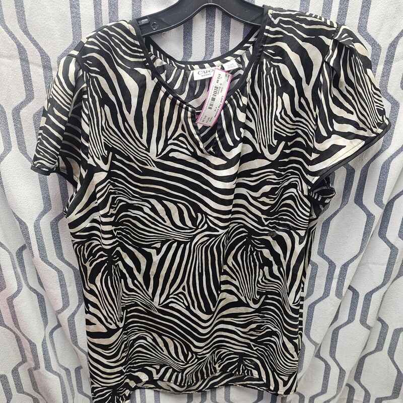 Short sleeve black and white blouse with touches of light tan throughout.