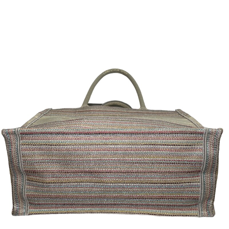 CHRISTIAN DIOR Canvas Embroidered Medium Stripes Book Tote in Beige and Multicolor. This lovely tote is crafted of embroidered canvas. The bag features beige canvas rolled top handles with CHRISTIAN DIOR embroidered and opens to a spacious fabric interior.<br />
Production Year: 2021<br />
<br />
Dimesions<br />
Base length: 14 in<br />
Height: 10.5 in<br />
Width: 6.25 in<br />
Drop: 6.25 in