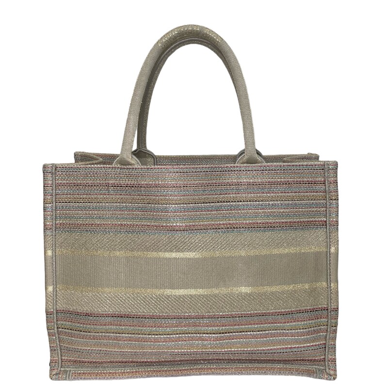 CHRISTIAN DIOR Canvas Embroidered Medium Stripes Book Tote in Beige and Multicolor. This lovely tote is crafted of embroidered canvas. The bag features beige canvas rolled top handles with CHRISTIAN DIOR embroidered and opens to a spacious fabric interior.
Production Year: 2021

Dimesions
Base length: 14 in
Height: 10.5 in
Width: 6.25 in
Drop: 6.25 in