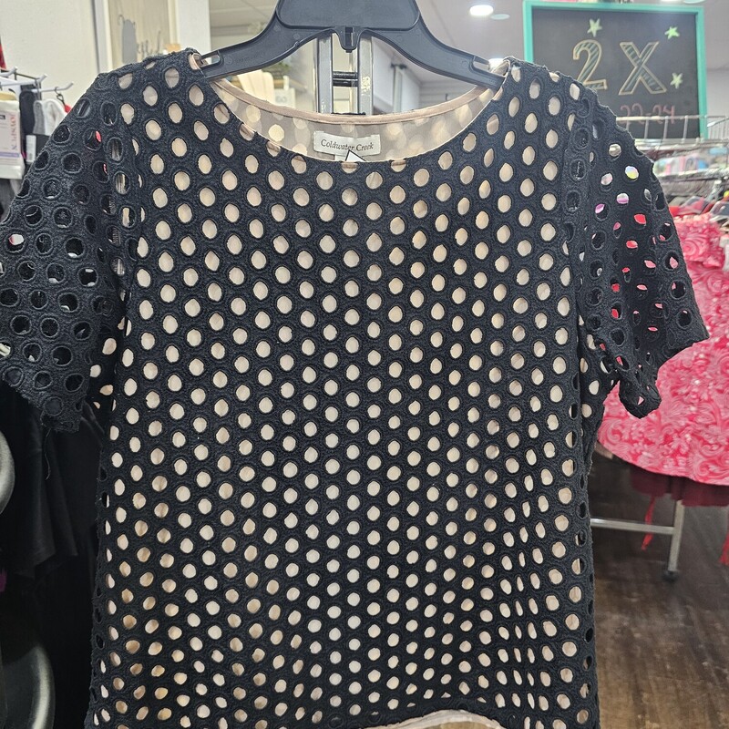 Super cute blouse with short sleeves and a soft pink liner layer and a black layer with polka dots cut into the material.