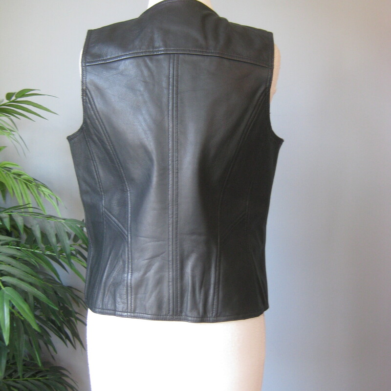 No frills black leather riding vest by<br />
Harley-Davidson<br />
fully lined<br />
snap front<br />
marked size M (seems a little small for a modern size Medium gal, esp if busty<br />
Flat measurements:<br />
armpit to armpit: 18.75<br />
width at hem: 19.75<br />
length: 23<br />
<br />
perfect condtion.<br />
<br />
thanks for looking!<br />
#69164