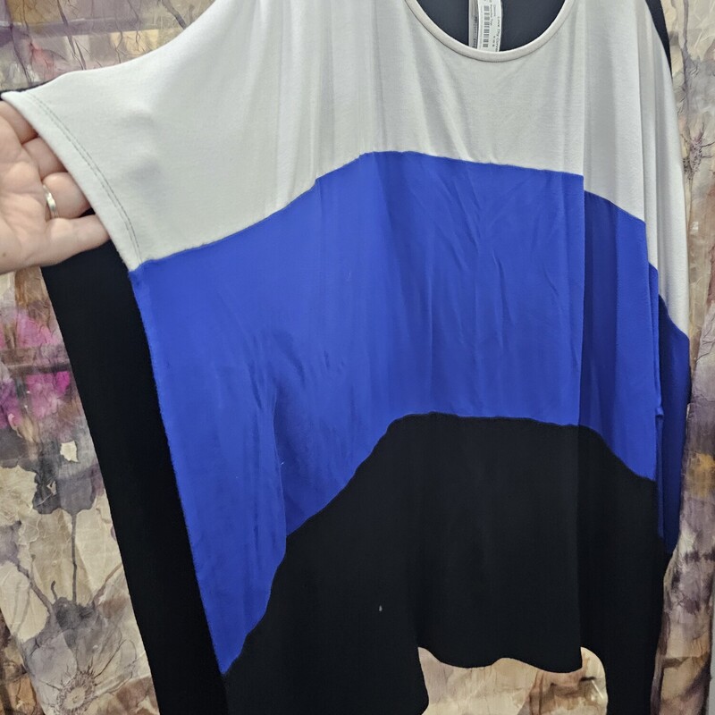 Poncho style top in black white and blue with solid black panel in back. Slit style arm holes.