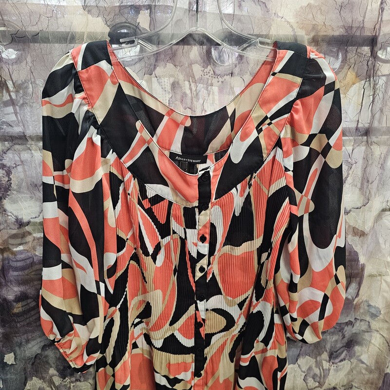 Short sleeve blouse in white black tan and orange print, button up front and pleated material