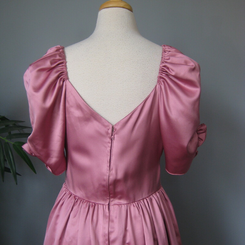 Vtg Satin Gown, Pink, Size: Medium<br />
Amazing gown in pink satin.<br />
The main feature are the pretty puffy full sleeves with rosettes.<br />
The tops of the sleeves are elasticized, so you could experiment with wearing this off the shoulders.<br />
Sweetheart neckline<br />
Simple but full gathered skirt - add a crinoline for extra fullness.<br />
center back zipper<br />
Excellent vintage condition, a couple of very small spots.<br />
<br />
No tags - possibly handmade<br />
Flat measurements, please double where appropriate:<br />
armpit to armpit: 17<br />
waist: 14.5<br />
hip: 25.5<br />
length: 54 (in the back)<br />
<br />
Thanks for looking!<br />
#56939