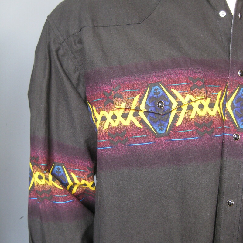 This is a 100% Cotton mens brush popper style shirt by Wrangler<br />
Soft black in color with bright yellow , blue and burgundy southwestern design across the chest and arms.<br />
black pearlized snaps on the front, the cuffs and the two working chest pockets.<br />
Marked size XL<br />
<br />
Here are the flat measurements, please double where appropriate:<br />
Shoulder to Shoulder: 22<br />
Armpit to Armpit: 25.5<br />
Underarm sleeve seam length: 21.75<br />
Overall length: 31<br />
<br />
excellent conditin, feels crisp like it hasn't been washed yet<br />
Thanks for looking!<br />
#38229