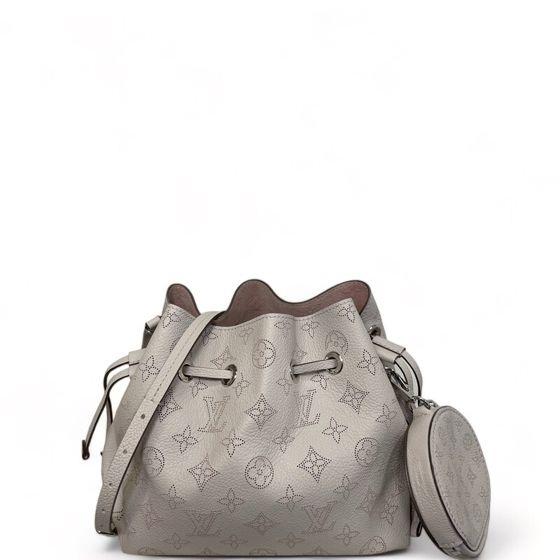 Louis Vuitton Bella, Galet<br />
Louis Vuitton unveils the Bella bucket bag in Mahina calf leather with its perforated Monogram pattern. The bag’s small size and the attached round coin purse, featuring a miniature version of the perforated Monogram motif on one side, make it modern, desirable and trendy. The sophisticated leather and metal mixed handle associated with a removable leather strap bring versatility.<br />
<br />
7.5 x 8.7 x 5.5 inches<br />
(length x Height x Width)<br />
Galet Gray<br />
Mahina perforated calf leather<br />
Calf-leather trim<br />
Microfiber lining<br />
Silver-color hardware<br />
Round coin purse<br />
Leather drawstring to secure belongings<br />
4 protective metal bottom studs<br />
Strap:Removable, adjustable<br />
Strap drop: 19.7 inches<br />
Strap drop max: 22.0 inches<br />
Handle:Single, removable<br />
Year: Mircochip