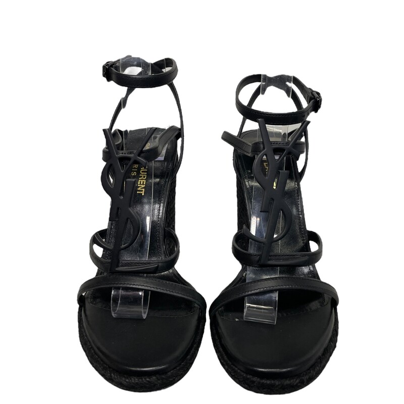 YSL Cassandre Black Wedges<br />
Size: 36.5<br />
Saint LaurentCassandra Wedge Espadrilles<br />
Espadrilles made with metal free tanned leather with jute wedge heel, featuring straps decorated with metal YSL initials and an adjustable buckle.<br />
Total Heel Height:  4.5 Inches<br />
Arch Height:  4.1 Inches<br />
Platform Height:  0.3 Inches<br />
Leather Sole<br />
Black Metal Hardware