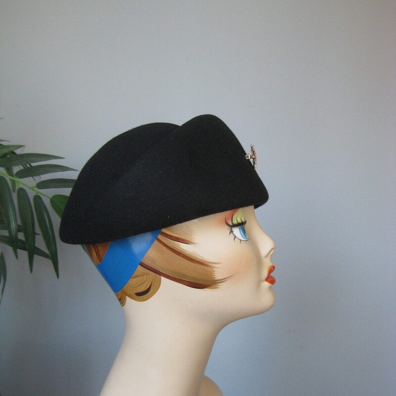 Wool Bowler W/ Pin, Black, Size: None<br />
This is a sculptural black hat from the 1950s.  It will basically read as a pillbox.  It's made of black wool felt and has a gorgeous star like brooch attached in gold tone metal, rhinestones and coral colored round beads.<br />
The inner brim measures 21 1/2 around.  You can wear it as shown, kind of front and center, try it tilted or further back as well.<br />
<br />
Thanks for looking!<br />
#69368