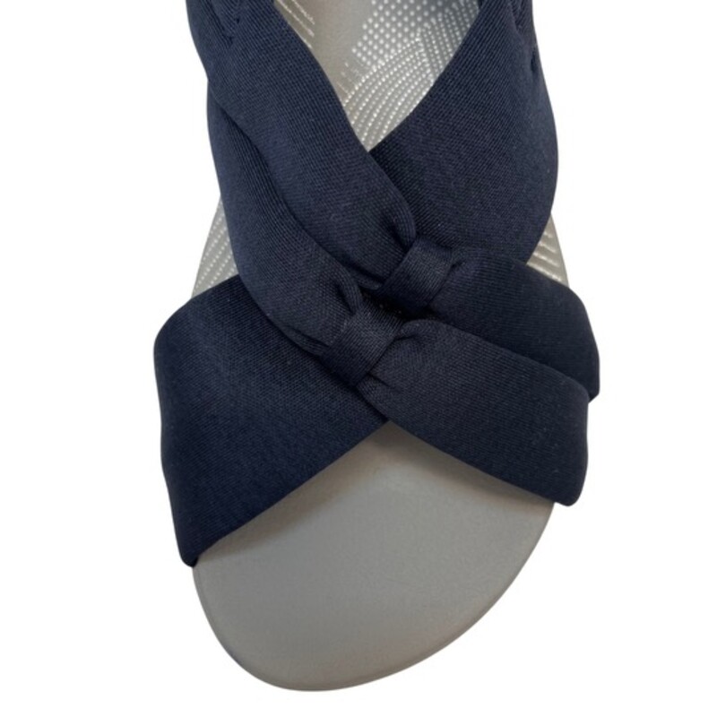 NEW Cloudsteppers by Clark Arla Belle Sandals<br />
Color: Navy<br />
Size: 5.5<br />
Flexible crisscross straps with knotted detail, adjustable hook-and-loop backstrap<br />
Padded insole, EVA midsole, textured outsole<br />
Bottom construction: Arla<br />
Approximately 1-5/8H heel<br />
Fit: true to size<br />
Fabric upper; man-made balance