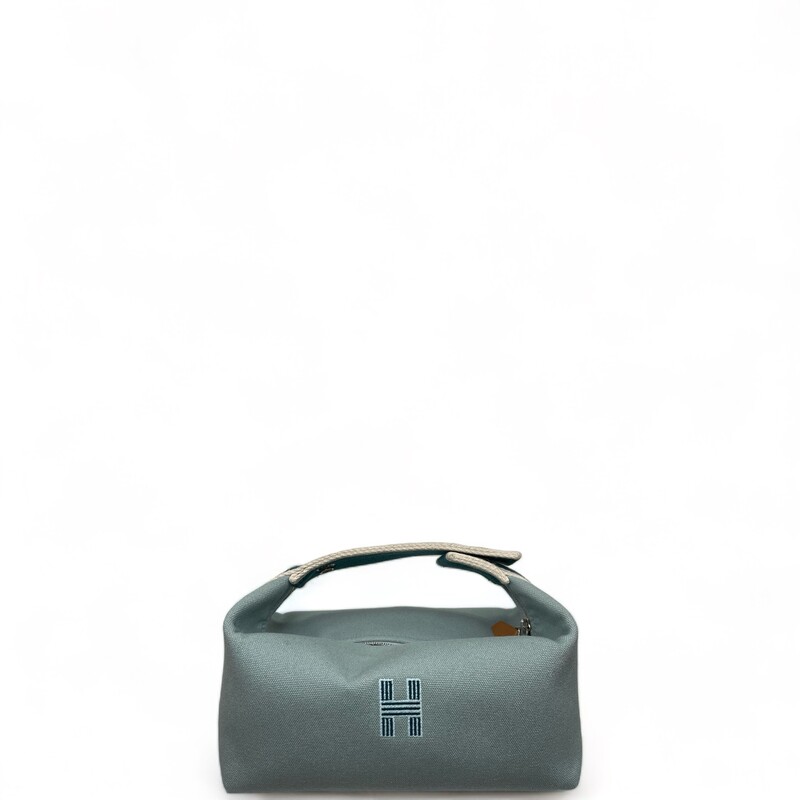 HERMES Canvas Small  Pouch Handbag . The pouch is fabricated in canvas and consists of a snap closure on the top handle, along with a burgundy stripe around the bag. The zipper opens to a canvas interior with patch pockets.

Dimensions:
Length: 8.25 in
Height: 4 in
Width: 4.75 in
Drop: 3 in