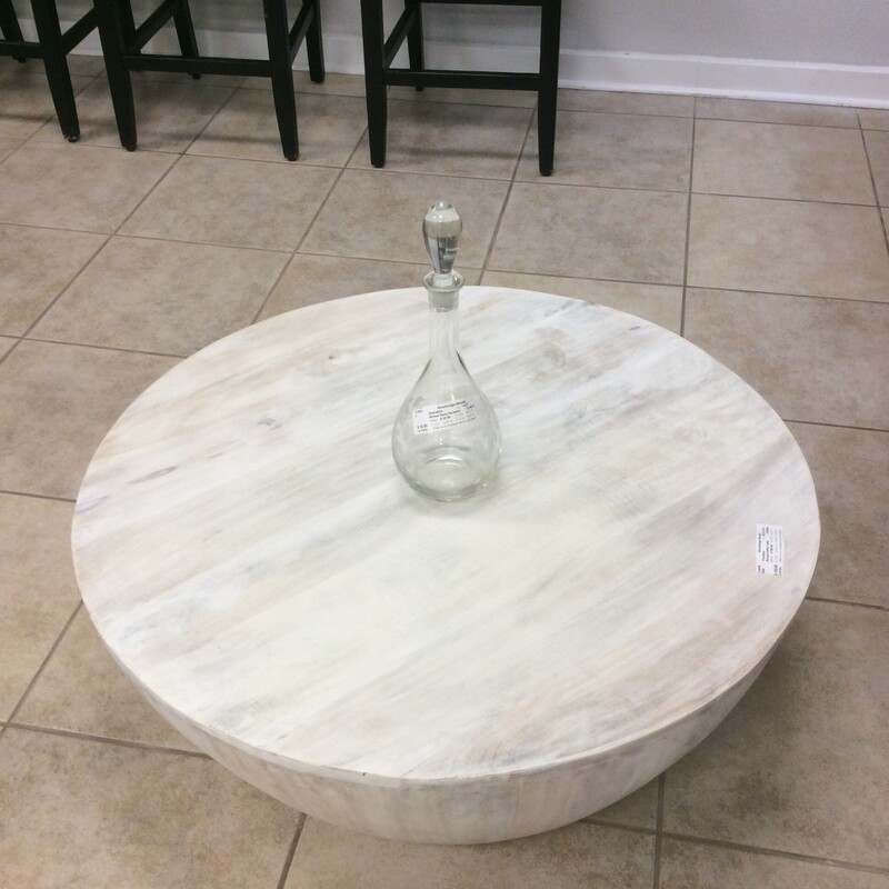 Love This!! I would call it kind of an urban, rusticy chic. This low lying round coffee table apprears to be a painted pine, off- white but much of the natural wood grain coming through. It's less than 13 inches in height so does require the right height furniture to accompany it.