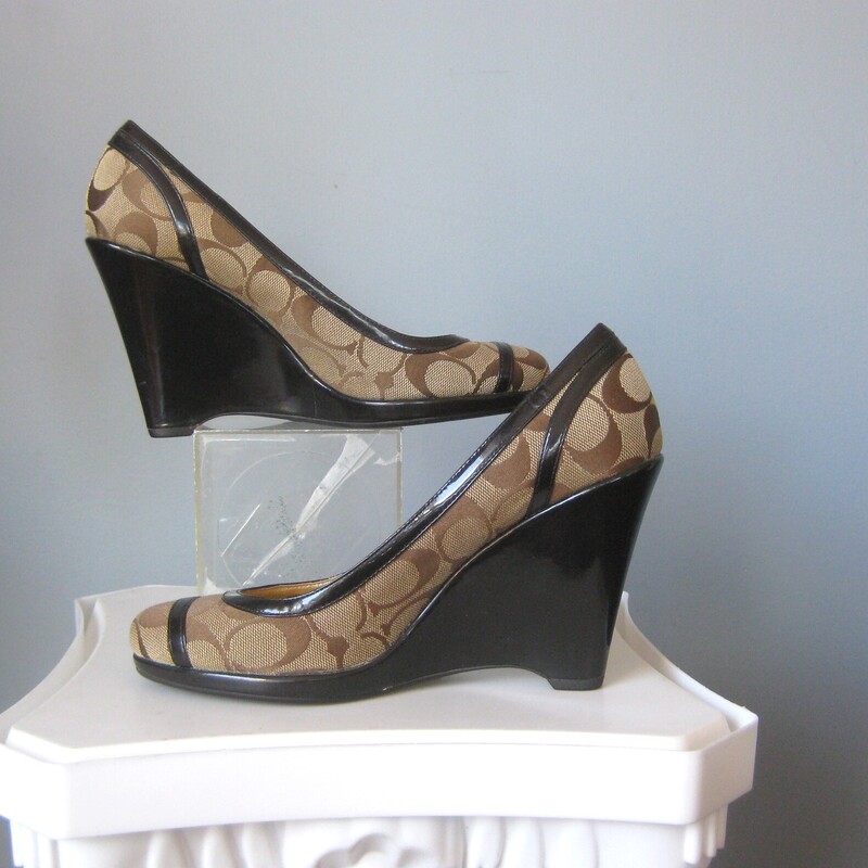 Great lookin pair of Coach KerryAnn Wedge heels in brown signature logo canvas with black patent leather cladding and trim.<br />
the wedge is quite high, just about 4 at the back.<br />
Size 7.5<br />
excellent very gently pre-owned condition<br />
<br />
Thanks for looking!<br />
#71263