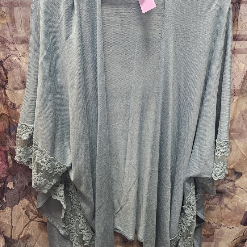 No close half sleeve light weight shawl style sweater in a soft teal with lace.